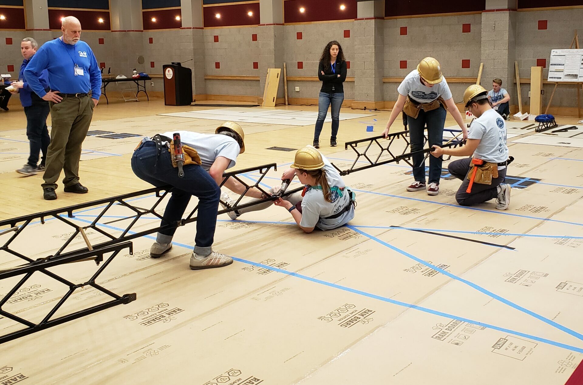 Four students building a steel bridge.