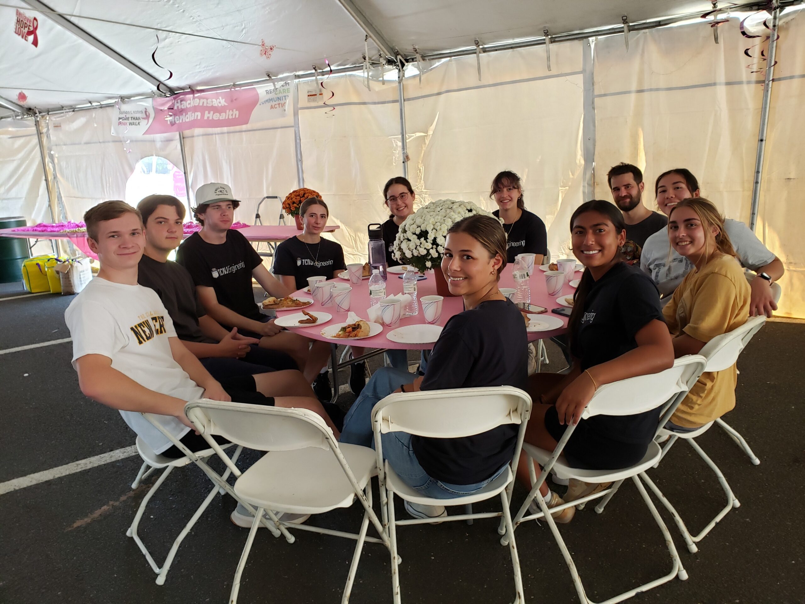 A group of 11 students sits at a round table.