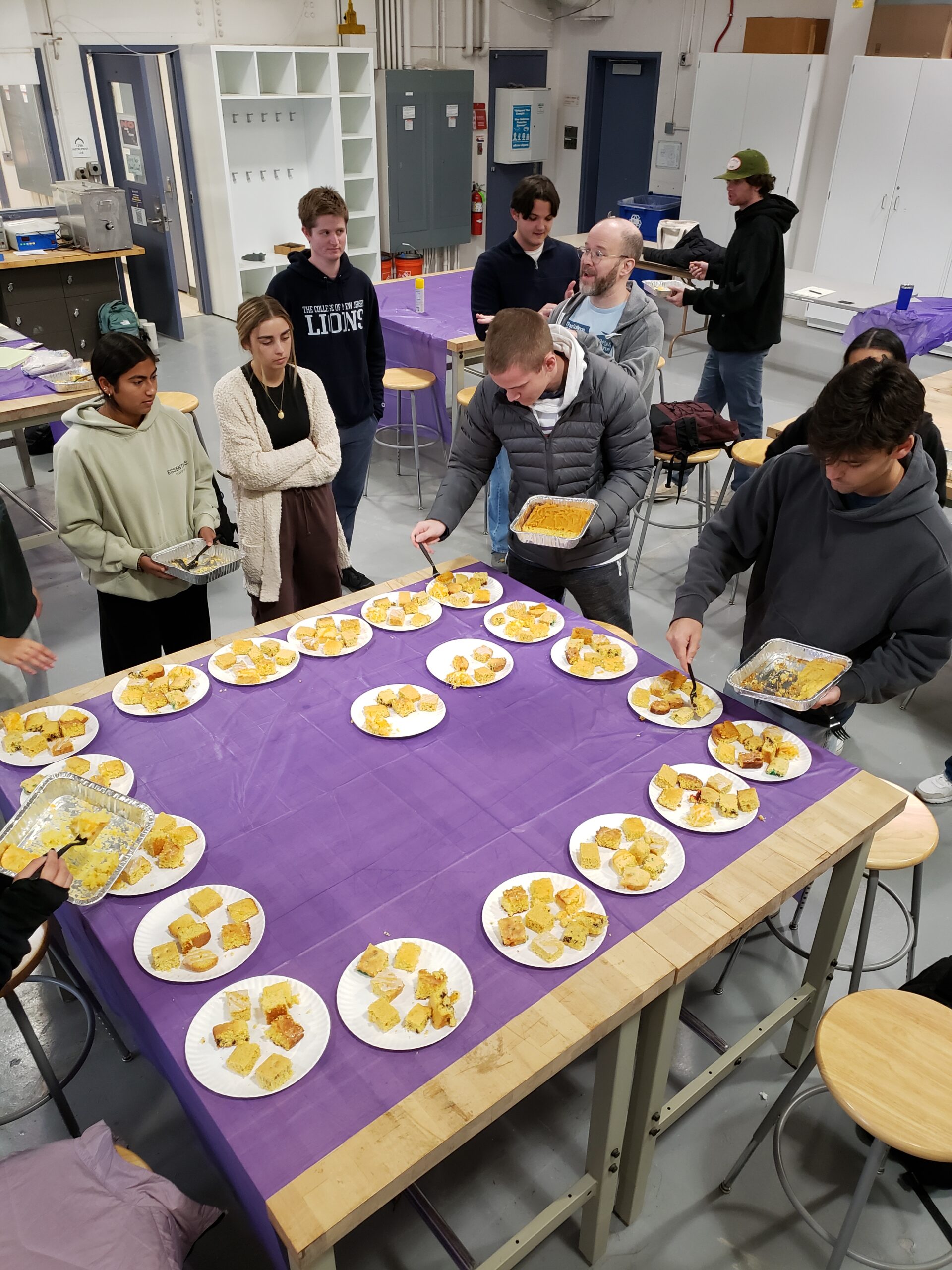 Students are placing cornbread pieces on plates.