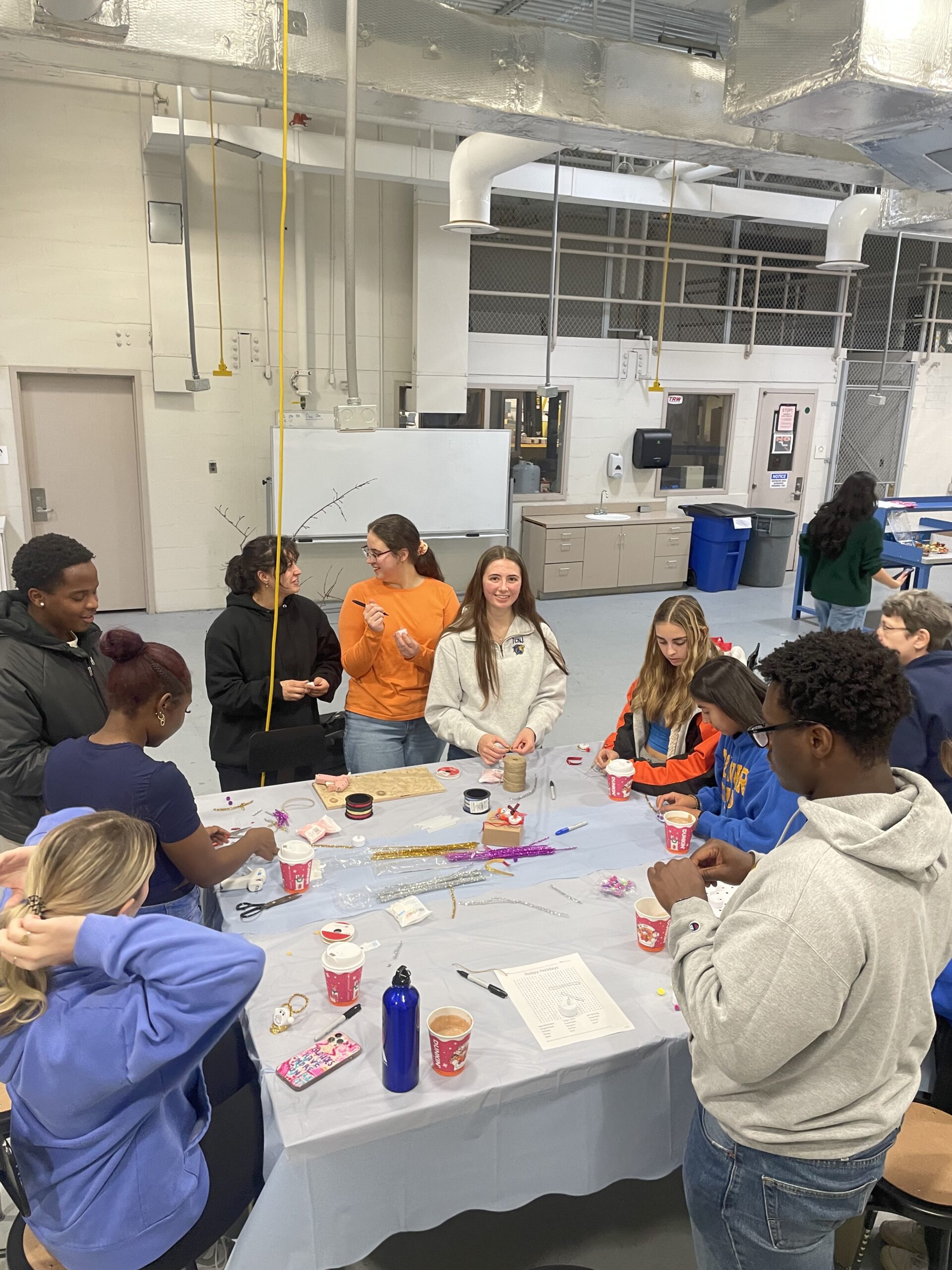 Students standing around a table making ornaments