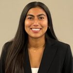  headshot of a female student with dark brown hair in a black suit and white shirt