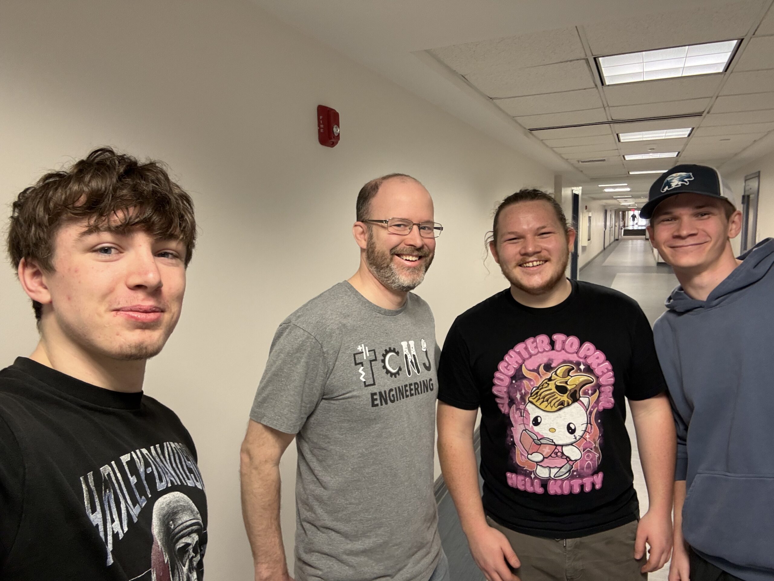 Four men standing in a hallway.