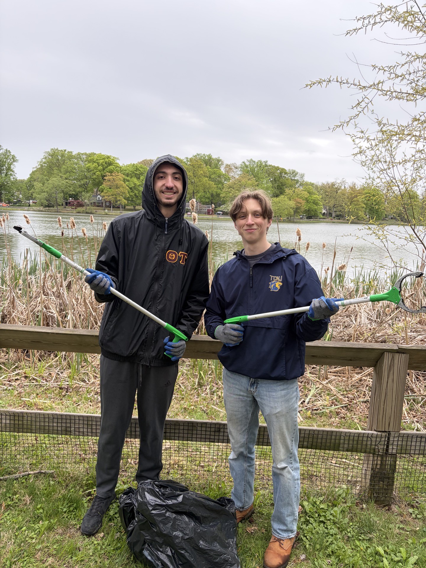Two male students holding garbage grabbers.