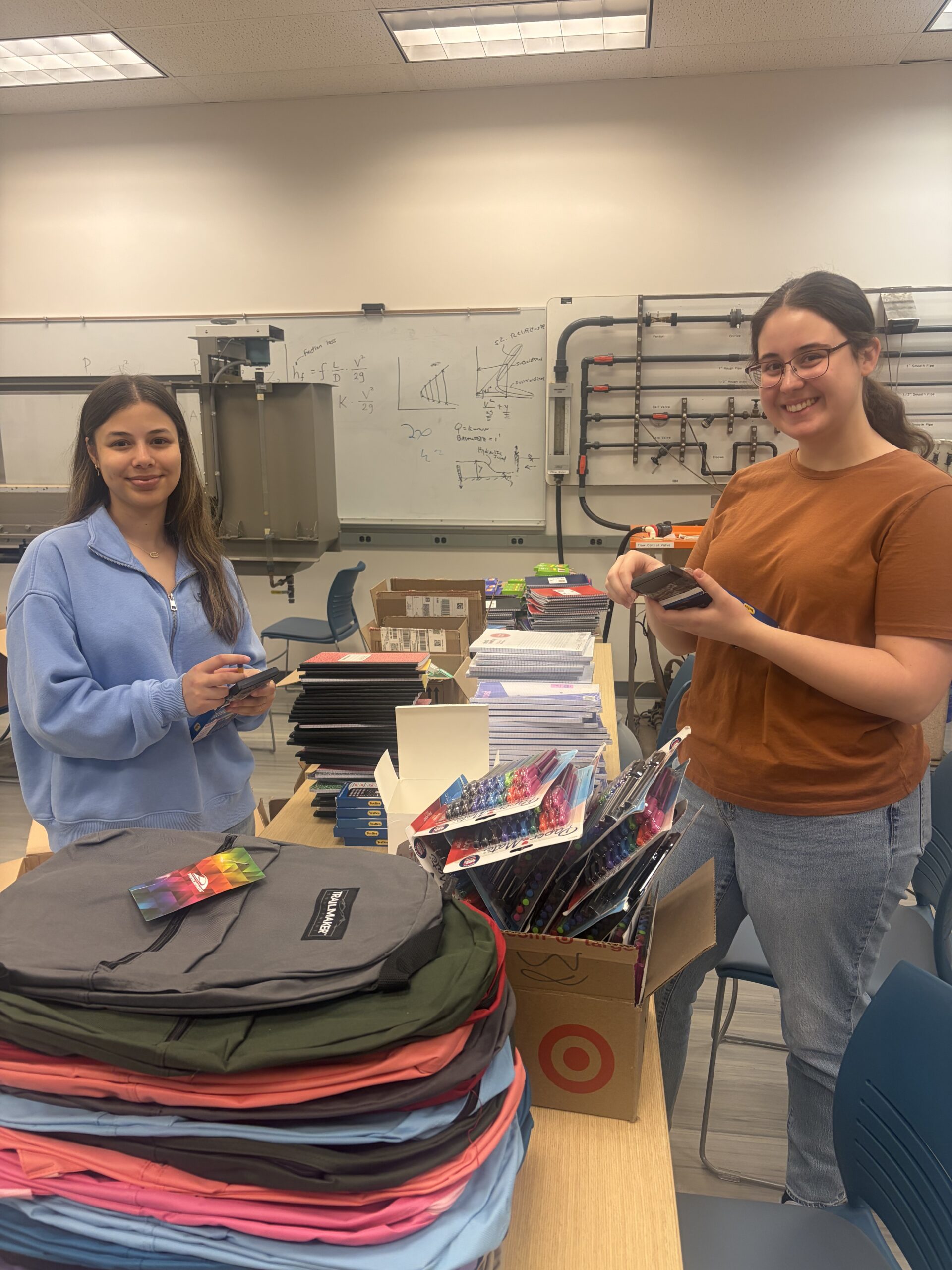 Two students working on assembling the backpacks