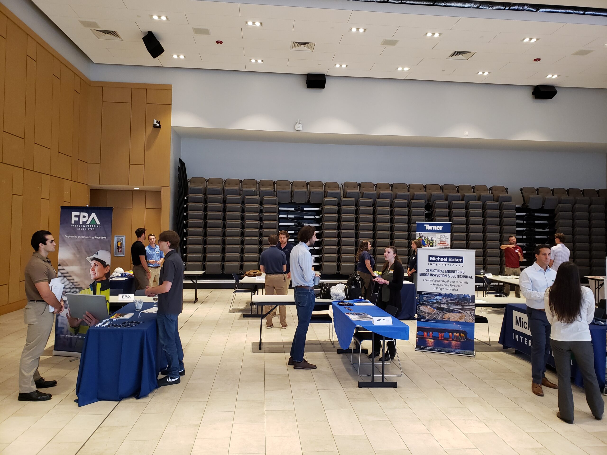 Students are talking to alumni at various stations. Many alumni had posters representing their companies.